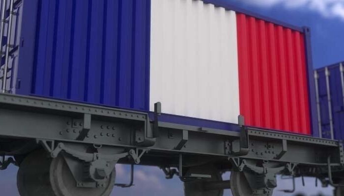 Freight train carrying blue, white, and red shipping containers
